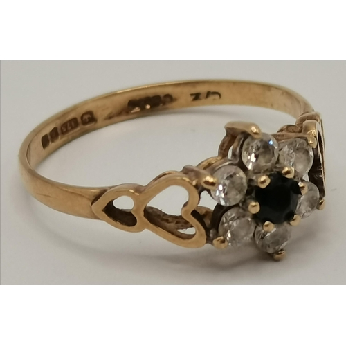 434 - A 9 carat gold cluster ring, the central blue stone surrounded by six white stones in a flowerhead f... 