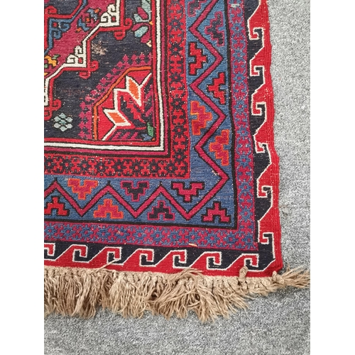 900 - A large kilim rug, decorated in blues, pinks and purples, (a/f). Approx. 388cm by 207cm