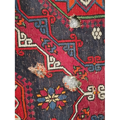 900 - A large kilim rug, decorated in blues, pinks and purples, (a/f). Approx. 388cm by 207cm