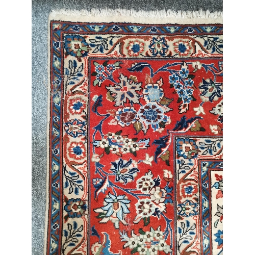 901 - A large Afghan carpet, the beige field with a mauve medallion and all-over multicoloured scrolling f... 