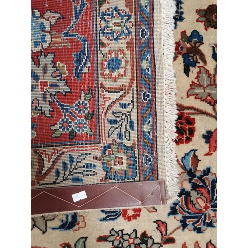 901 - A large Afghan carpet, the beige field with a mauve medallion and all-over multicoloured scrolling f... 