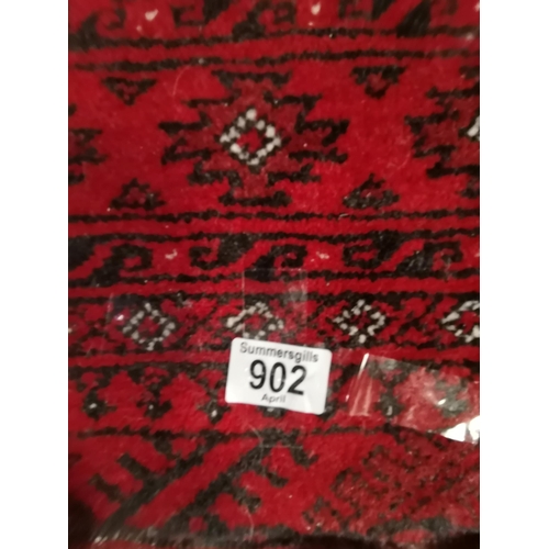 902 - A small Afghan rug, the red ground with two columns of black and white guls, the main border enclose... 