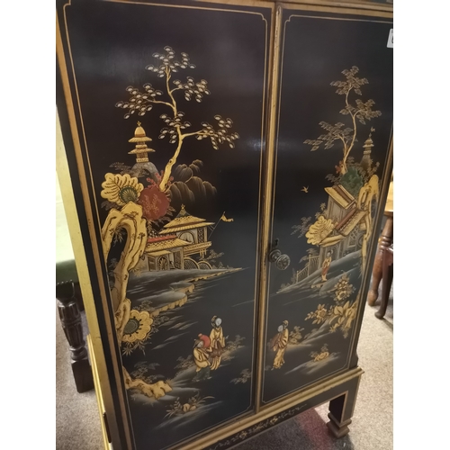 661 - A Chinese style black lacquer drinks cabinet with highly decorative floral detail, female figures, p... 