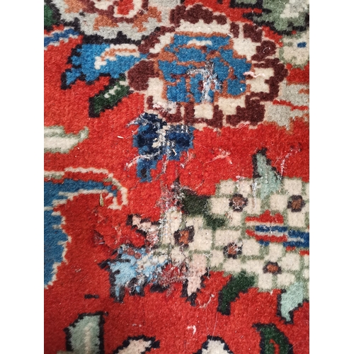 901 - A large Afghan carpet, the beige field with a mauve medallion and all-over multicoloured scrolling f... 