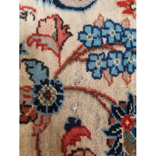 901 - A large Afghan carpet, the beige field with a mauve medallion and all-over multicoloured scrolling f... 