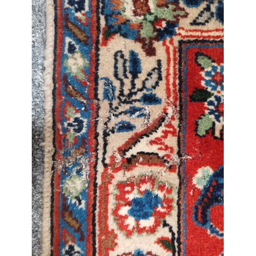 901 - A large Afghan carpet, the beige field with a mauve medallion and all-over multicoloured scrolling f... 