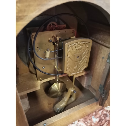 631a - An Antique oak mantel clock with brass bracket feet and having a silvered dial. With key 30cm x 25cm