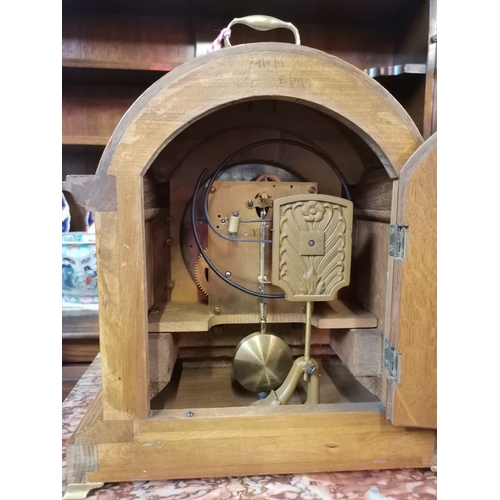 631a - An Antique oak mantel clock with brass bracket feet and having a silvered dial. With key 30cm x 25cm