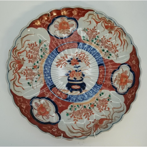 143 - A collection of five Japanese Imari wall chargers and plates, comprising a large pair of chargers, a... 