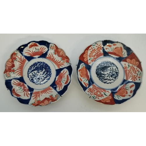 143 - A collection of five Japanese Imari wall chargers and plates, comprising a large pair of chargers, a... 