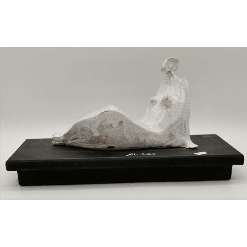 163 - Modernist ceramic figure of a reclining female, with white crackle glaze, to a black rectangular pli... 