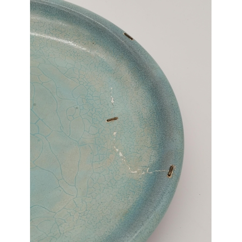 188 - A Chinese celadon and purple glaze large dish, the front in celadon green, the underside mottled pur... 