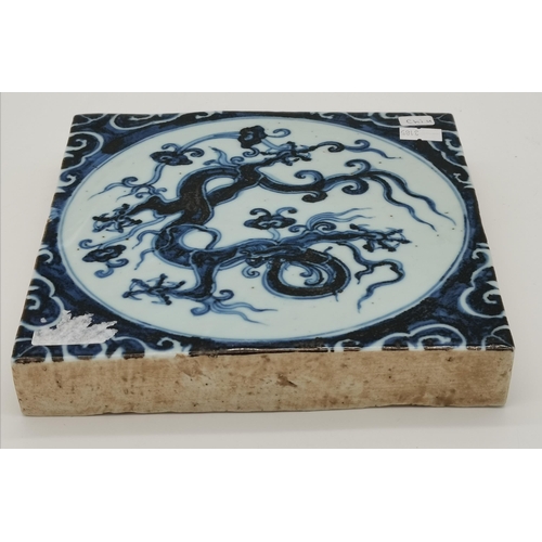 189 - A Chinese blue and white glazed tile, the central roundel decorated with a five-toed dragon. 19.7cm ... 