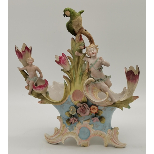 190 - Two ceramic centrepieces, likely German, each adorned with putti and flowers, one with a basket to t... 