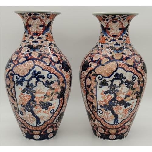 2 - A pair of Japanese Imari vases decorated with figures, animals and foliage, with gilded detail. (2) ... 