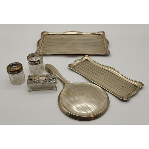 392A - A silver-plated part dressing table set comprising two trays and a hand mirror with engine-turned ba... 