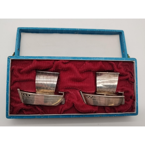 404A - A novelty Japanese silver cruet set, marked 'STERLING 950', the salt and pepper each cast as a boat ... 