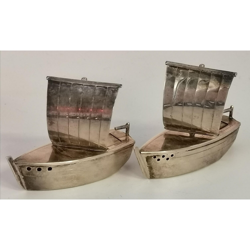 404A - A novelty Japanese silver cruet set, marked 'STERLING 950', the salt and pepper each cast as a boat ... 