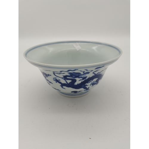 212 - A Chinese Qianlong porcelain blue and white bowl, 1800s, decorated with five-toed dragons to the ext... 