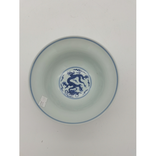 212 - A Chinese Qianlong porcelain blue and white bowl, 1800s, decorated with five-toed dragons to the ext... 