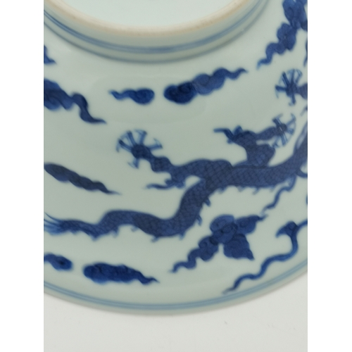 212 - A Chinese Qianlong porcelain blue and white bowl, 1800s, decorated with five-toed dragons to the ext... 