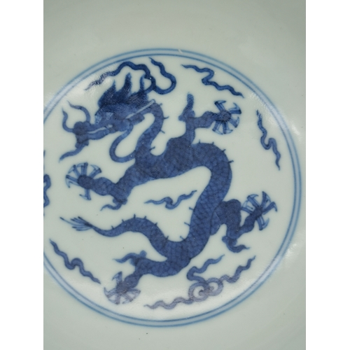 212 - A Chinese Qianlong porcelain blue and white bowl, 1800s, decorated with five-toed dragons to the ext... 