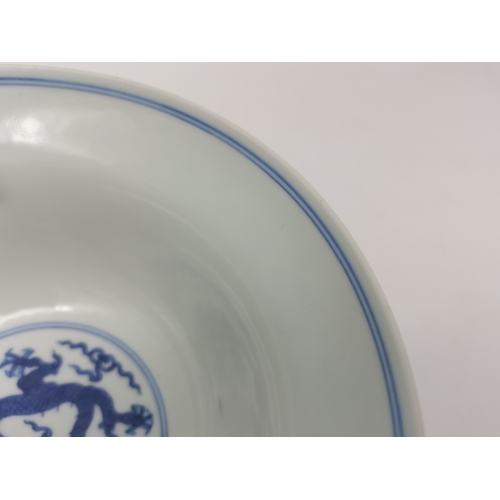 212 - A Chinese Qianlong porcelain blue and white bowl, 1800s, decorated with five-toed dragons to the ext... 