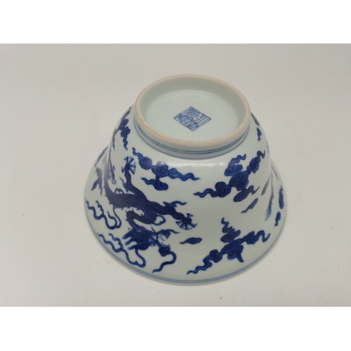 212 - A Chinese Qianlong porcelain blue and white bowl, 1800s, decorated with five-toed dragons to the ext... 