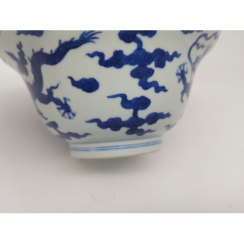 212 - A Chinese Qianlong porcelain blue and white bowl, 1800s, decorated with five-toed dragons to the ext... 