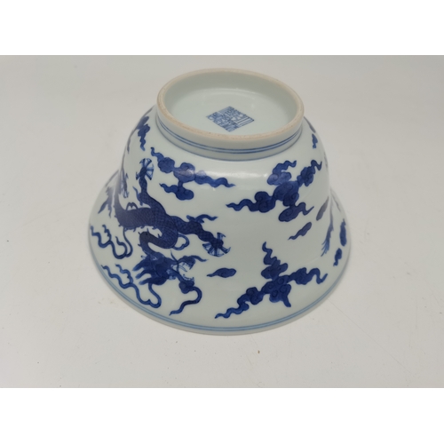 212 - A Chinese Qianlong porcelain blue and white bowl, 1800s, decorated with five-toed dragons to the ext... 