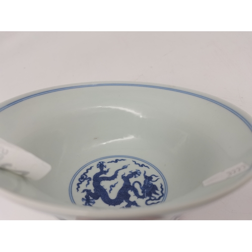 212 - A Chinese Qianlong porcelain blue and white bowl, 1800s, decorated with five-toed dragons to the ext... 