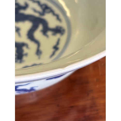 212 - A Chinese Qianlong porcelain blue and white bowl, 1800s, decorated with five-toed dragons to the ext... 