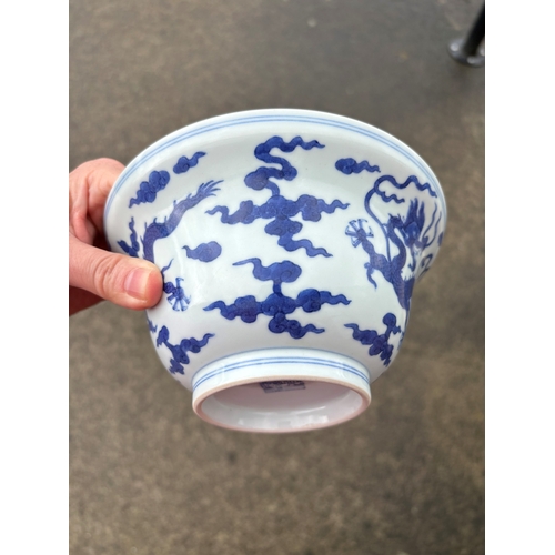 212 - A Chinese Qianlong porcelain blue and white bowl, 1800s, decorated with five-toed dragons to the ext... 