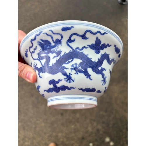 212 - A Chinese Qianlong porcelain blue and white bowl, 1800s, decorated with five-toed dragons to the ext... 