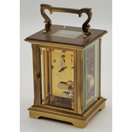 76 - A brass carriage clock, signed Matthew Norman, with black Roman numerals, the brass case with swing ... 