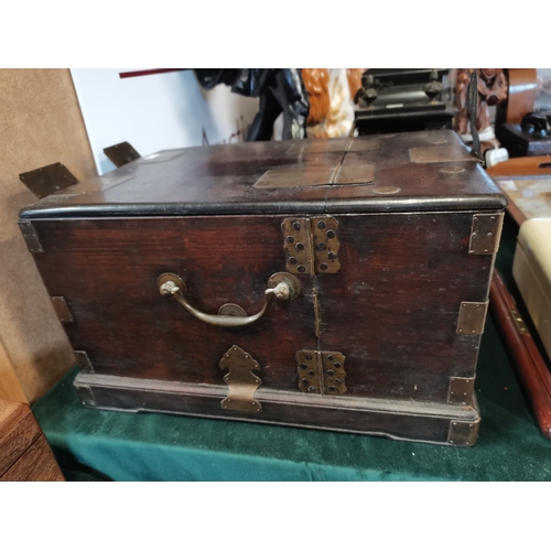 8 - A Chinese hardwood brass-bound travel jewellery/vanity case, the pair of hinged doors over a carved ... 