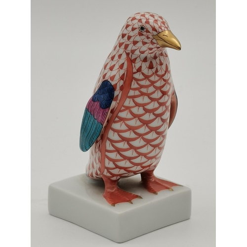 106 - A Herend porcelain penguin, decorated in red and white, with blue/purple wings and gold beak, on a s... 