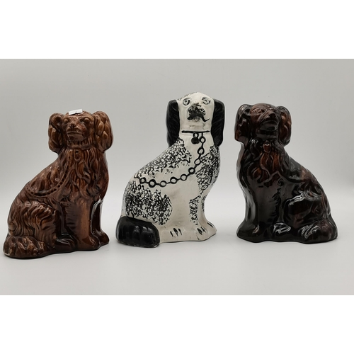 120 - A pair of Midwest Stoneware Rockingham treacle glazed Spaniels, c.1900; together with a black and wh... 