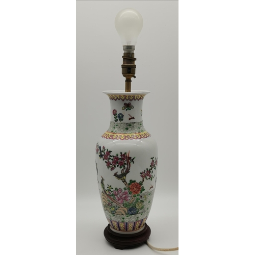 14 - A Chinese famille rose vase decorated with birds and butterflies in a floral setting, the base drill... 