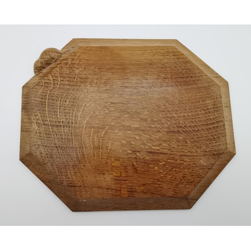 189 - Robert Thompson, a Mouseman oak breadboard, elongated octagonal, the surface lightly adzed, with car... 