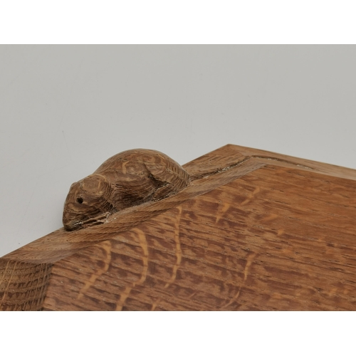 189 - Robert Thompson, a Mouseman oak breadboard, elongated octagonal, the surface lightly adzed, with car... 