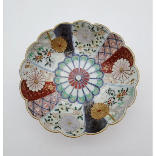 213 - A Japanese Imari bowl, the lobed side variously decorated in reds, blues, greens and with gilding, u... 