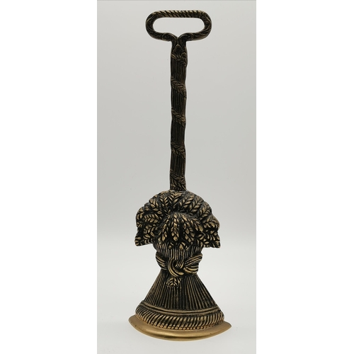 4 - A brass door porter, in the form of a wheatsheaf, with loop handle. 39cm high