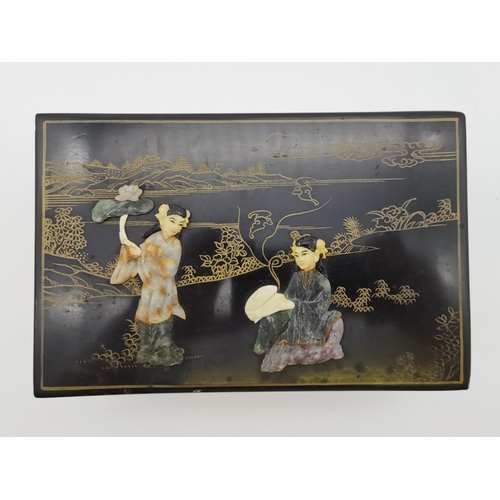 79 - An oriental lacquered jewellery box, rectangular, with gilt decoration, the cover inlaid with hardst... 