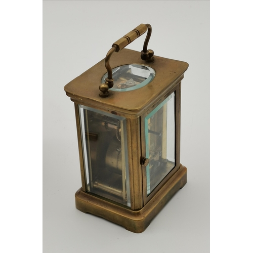 81 - A brass carriage clock, unsigned, with black Roman numerals, the movement stamped A.C.C. / L., the b... 