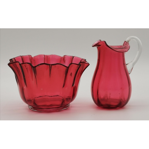 87 - A small group of assorted cranberry glass wares comprising a fluted bowl, baluster jug, pair of smal... 