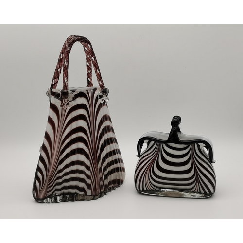 91 - Two novelty 'handbag' glass vases, white interior overlaid with dark purple striped decoration, the ... 