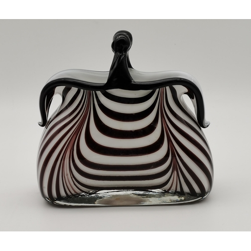 91 - Two novelty 'handbag' glass vases, white interior overlaid with dark purple striped decoration, the ... 