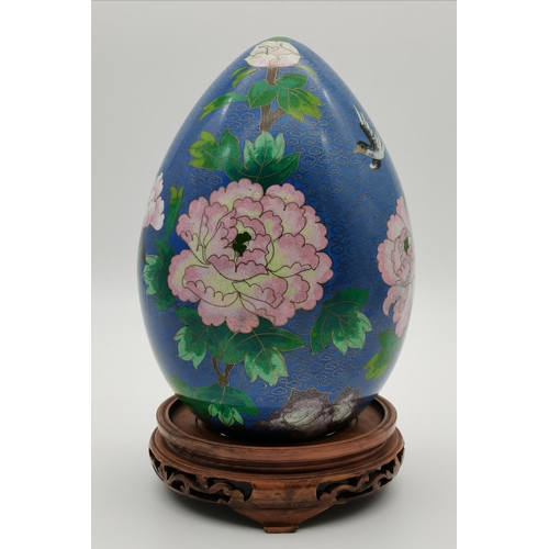 98 - A large cloisonné egg on a carved and pierced hardwood stand, decorated with blossom boughs, flowers... 