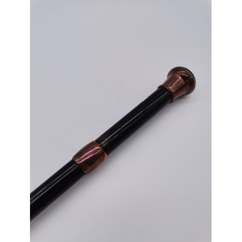 15 - Antique ebonised walking cane with copper domed pommel top and tip. H94cmCondition StatusGood: In go... 